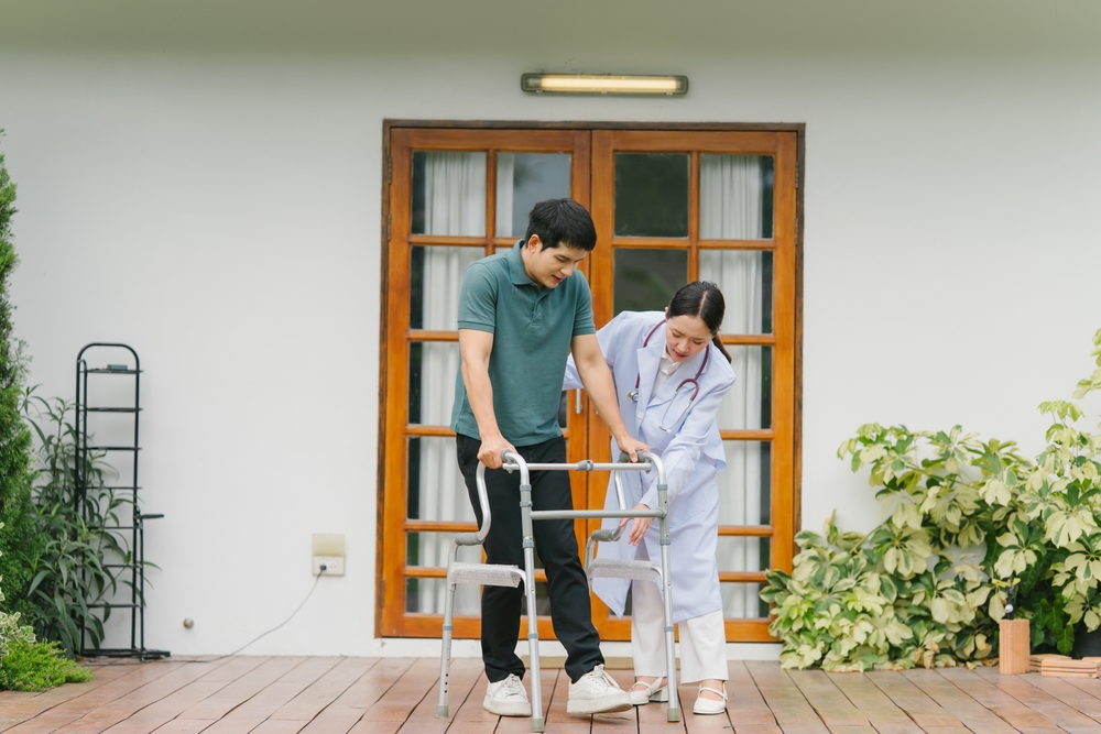 Doctor Assisting Patient With Walker During Rehabilitation